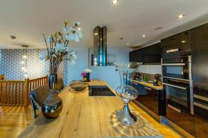 a kitchen with a wooden table with a vase of flowers at Spacious 3-Bed Penthouse with City Sky Line Views in Sheffield +13 photos