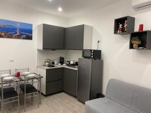 una piccola cucina con frigorifero e tavolo di The Nest Of Via Toledo a Napoli
