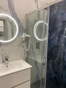 un bagno con doccia, lavandino e specchio di The Nest Of Via Toledo a Napoli Altre 18 foto
