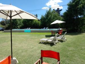 two chairs and an umbrella in a yard at Casa Magnolias in Tandil