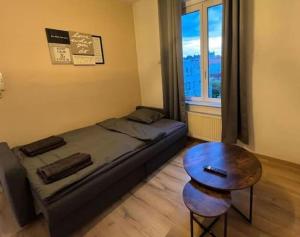 1 dormitorio con cama, mesa y ventana en Cosy Apartment Merode 2, en Bruselas