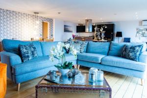 een woonkamer met een blauwe bank en een tafel bij Spacious 3-Bed Penthouse with City Sky Line Views in Sheffield