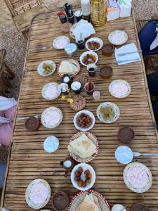 uma mesa de madeira com pratos de comida em Agpeninshal Ecolodge em Siwa