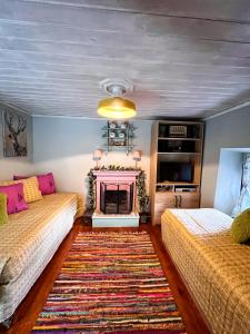 a living room with two beds and a fireplace at DandyVillas-Vintage Cottage House-Pelion-Argalasti-Kallithea in KallithÃ©a