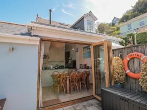 a patio with a table and chairs and a kitchen at Kipper Lodge in Dartmouth