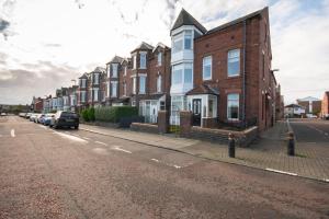 uma fila de casas de tijolos ao lado de uma rua em Dwellcome Home Ltd 5 Double Bedroom 6 Beds Townhouse 2 Bathrooms - see our site for assurance em South Shields