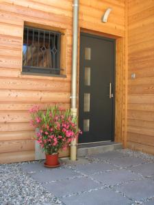 eine schwarze Tür eines Holzhauses mit Blumen in der Unterkunft Chalet de l'Infernet in Auris