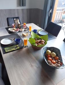 - une table avec de la nourriture et des boissons ainsi qu'un bol de fruits dans l'établissement Chalet de l'Infernet, à Auris