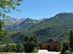 a wooden cabin with mountains in the background at Chalet de l'Infernet in Auris