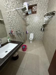 a bathroom with a sink and a toilet at Kaashi Flora - Luxury 3BHK in Varanasi