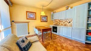 ein Wohnzimmer mit einem Sofa und einem Tisch in der Küche in der Unterkunft Appartamento Melezet 80 - Affitti Brevi Italia in Bardonecchia