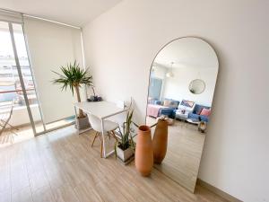 een woonkamer met een spiegel en een tafel bij Modern Ocean view Apt. Miraflores Center w/Balcony in Lima