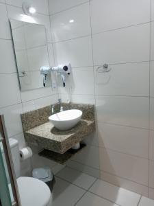 bagno con lavandino, servizi igienici e specchio di Familien Haus Pousada a Pomerode