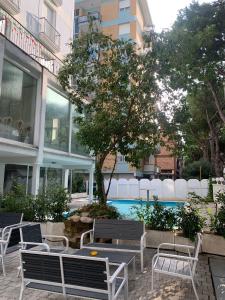リミニにあるホテル ロイヤル プラザ の建物前の一団のベンチと木