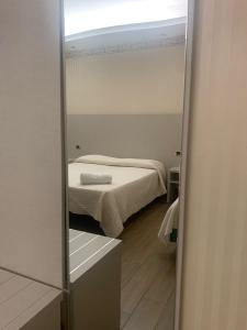 a mirror in a small room with a bed at Hotel Royal Plaza in Rimini