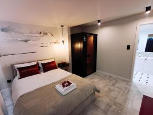 1 dormitorio con 1 cama grande con almohadas rojas en Apartament 34, en Ciechanów