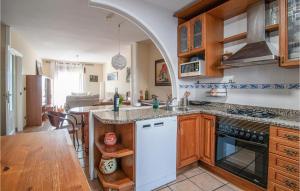eine Küche mit einem Torbogen über dem Waschbecken und einem Tisch in der Unterkunft Lovely Home In Saucelle With Kitchen in Saucelle
