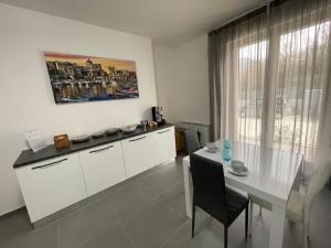 een witte keuken met een witte tafel en een raam bij Lotelito Apartment in Fisciano