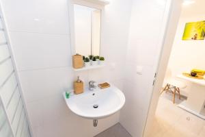 a white bathroom with a sink and a mirror at Central Apartments Vienna in Vienna