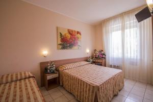 a hotel room with two beds and a window at Hotel Riviera Blu in Tirrenia