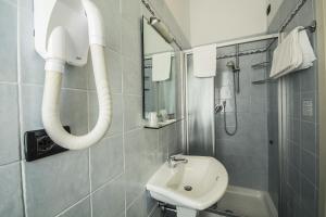 a bathroom with a sink and a shower and a mirror at Hotel Riviera Blu in Tirrenia