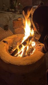 a person is standing around a fire pit at Agpeninshal Ecolodge in Siwa