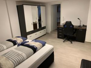 1 dormitorio con 2 camas, escritorio y silla en Ferienwohnung Bella, en Hühnerfeld