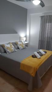 - une chambre dotée d'un grand lit avec des draps et des oreillers jaunes dans l'établissement MAR Y SIERRA DE TORROX, à Torrox