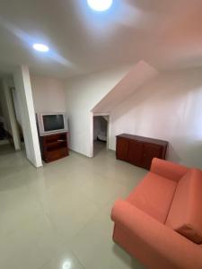 een woonkamer met een bank en een tv bij Apto a pasos del lago in Guatapé