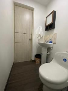 een badkamer met een wit toilet en een wastafel bij Apto a pasos del lago in Guatapé +13 foto's