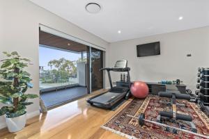 uma sala de estar com um ginásio com uma bicicleta ergométrica em Family Vacation Escapade Shops Beach and Sun Await em Perth