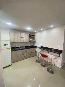 een keuken met een aanrecht en twee krukken erin bij Apto a pasos del lago in Guatapé