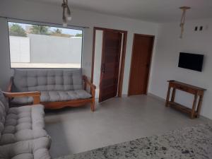 sala de estar con sofá y TV en Casa Bosque de Búzios 2km de Geribá, en Búzios