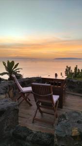 een bureau en stoelen op een terras met uitzicht op de oceaan bij Casa Rural Quinta Los Naranjos in Tigalate