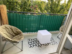 a chair and a white box on a balcony at Appartement Ping-Pong proche gare Gagny in Gagny