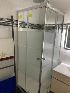 a glass shower in a bathroom with a sink at Appartement Ping-Pong proche gare Gagny in Gagny