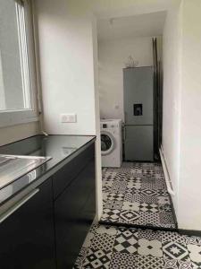 a kitchen with a washer and dryer in a room at Appartement Ping-Pong proche gare Gagny in Gagny