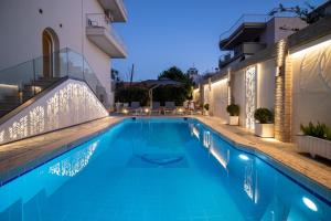 a swimming pool in a hotel at night at Alkyonis Hotel in Nea Kalikratia +43 photos