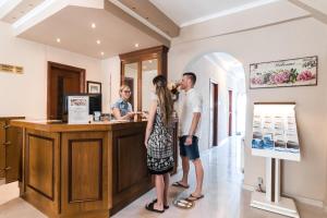 a man and a woman standing at a counter at Alkyonis Hotel in Nea Kalikratia