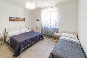 a bedroom with two beds and a window at Appartamento il Melograno in Rapolano Terme