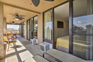 a room with a balcony with a bed and a table at Downtown Kona Condo with Pool Access Walk to Beach! in Kailua-Kona