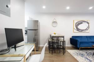 sala de estar con sofá azul y TV en 350-2A Prime gramercy Newly renovated 1BR sleeps 4, en Nueva York