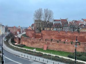 a city with a brick wall next to a street at Noctis Old Town in Warsaw