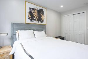 Un dormitorio con una cama blanca y una pintura en la pared en 350-2A Prime gramercy Newly renovated 1BR sleeps 4, en Nueva York