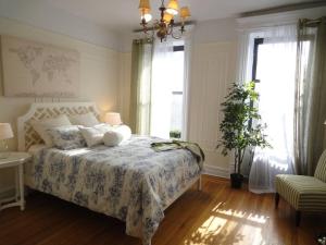 a bedroom with a bed with a floral bedspread and two windows at 211-3 Prime Union Square Large 1BR Great value in New York