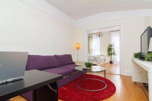 un soggiorno con divano viola e tappeto rosso di 211-3 Prime Union Square Large 1BR Great value a New York