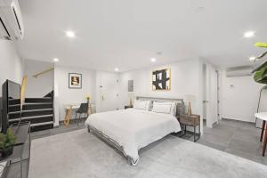 a bedroom with a white bed and a staircase at 149BK-101 New construction 2BR Private garden W-D in Brooklyn