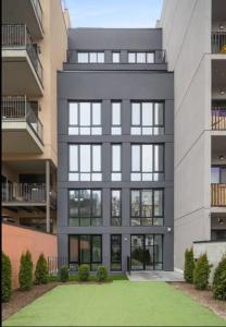 een groot gebouw met een gazon ervoor bij 149BK-101 New construction 2BR Private garden W-D in Brooklyn