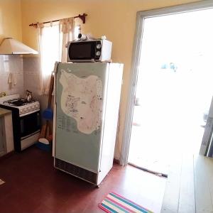 Un microondas encima de un refrigerador en una cocina. en La Candelaria, en Santa Rosa de Calamuchita 9 fotos más