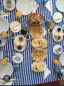 une table bleue et blanche avec des assiettes de nourriture dans l'établissement Jnane Ville Verte, à Casablanca